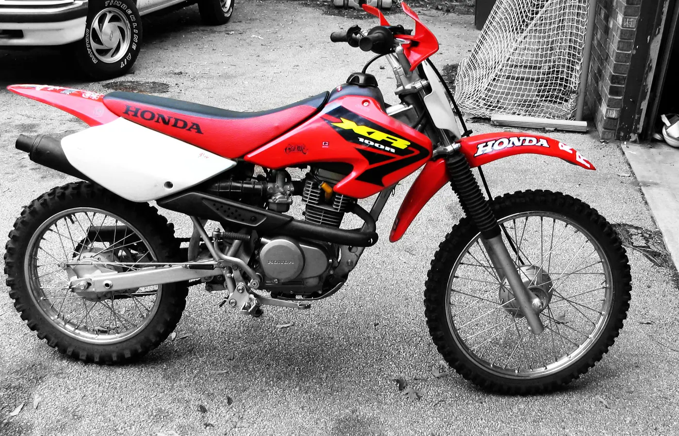 Honda XR100 roja y blanca vista de perfil